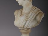 a white marble bust of a woman on a wooden base