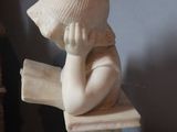 a small statue of a child sitting on a book