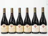 six bouteilles de vin sont alignées sur une surface blanche