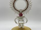 a small mirror on a stand with a bird on it