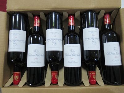 six bouteilles de vin rouge dans un carton sur une table
