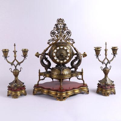 a clock that is sitting on a stand next to other items