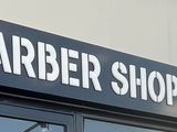 une voiture garée devant un salon de coiffure, au bord de la rue
