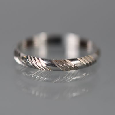un gros plan d'une bague en argent sur une surface réfléchissante