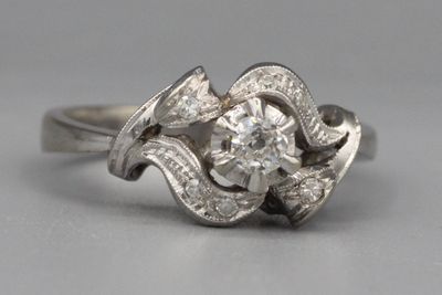 Bague en or ornée d’un brillant central dans un entourage de…