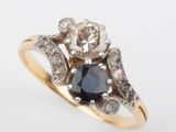 a close up of a diamond and sapphire ring on a white background