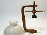 a white vase and a wooden stand with a light on it