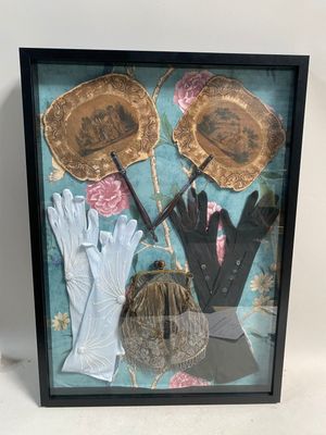 boîte-vitrine contenant des gants, des gants et un chapeau posés sur une table