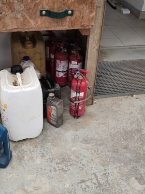 une petite armoire sur laquelle sont posés de nombreux bidons d'essence