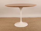 une table ronde avec un plateau en bois et un piètement blanc
