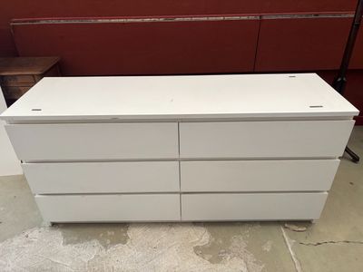 une commode blanche dans une pièce aux murs rouges