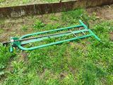 a green lawn mower laying in the grass