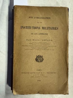 un vieux livre posé sur une table, à côté d'une nappe blanche