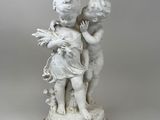 une image représentant une lampe sur laquelle se trouve une statue de deux enfants