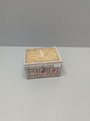 a small wooden box with writing on it sitting on a table