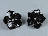 paire de boucles d'oreilles en forme de fleurs noires et blanches, ornées de diamants