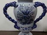 a blue and white vase sitting on a wooden table
