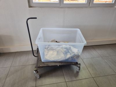a small cart with a plastic container on it