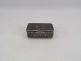 an antique silver cigarette case on a white surface
