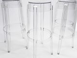 three clear stools sitting next to each other on a white surface
