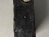 a close up of a black leather case with a button on it