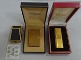 a gold lighter in a red box next to a black box