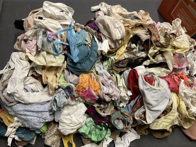 une pile de vêtements posée sur une table à côté d'une boîte