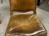 un fauteuil en cuir marron placé dans une pièce, à côté d'une table