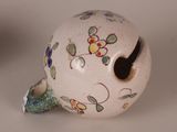 a small ceramic object with a flower design on it