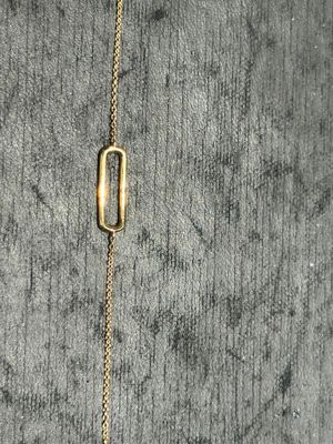 un gros plan d'un collier en or orné d'une barre