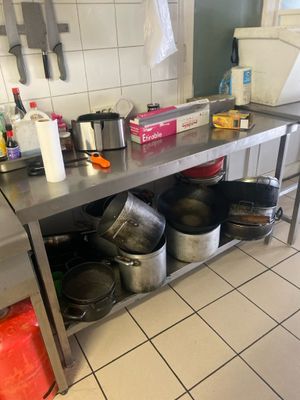 de nombreuses casseroles et poêles posées sur le plan de travail de la cuisine
