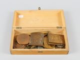 une boîte en bois remplie de pièces de monnaie de différentes sortes