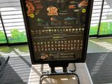 a menu board on a stand in front of a window