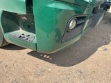 a close up of a green truck with a broken front bumper