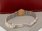 a silver and gold bracelet with a gold coin on it