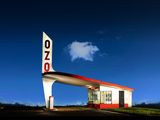 an image of a gas station at night with a blue sky in the background