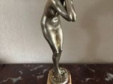 statue of a woman talking on a cell phone on a marble table