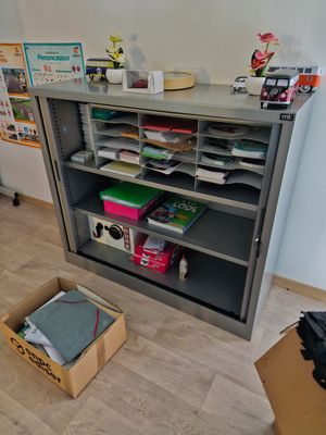 a box that is sitting on the floor in front of a bookcase