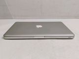 a silver apple laptop sitting on a white surface