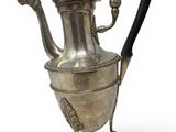 an antique silver tea pot with a handle on a stand