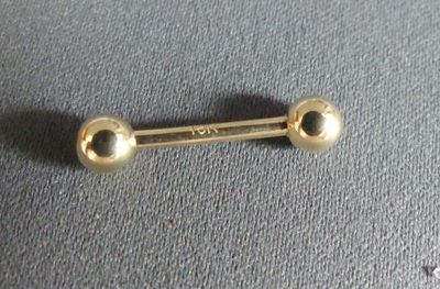a gold colored metal barbell with two balls on it
