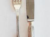 deux fourchettes et un couteau sur une table blanche