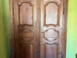une armoire en bois dans une pièce aux murs verts