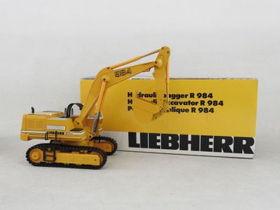 a yellow toy excavator that is next to a box