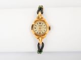 un gros plan d'une montre-bracelet posée sur une serviette blanche