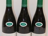trois bouteilles de vin sont alignées sur une surface blanche