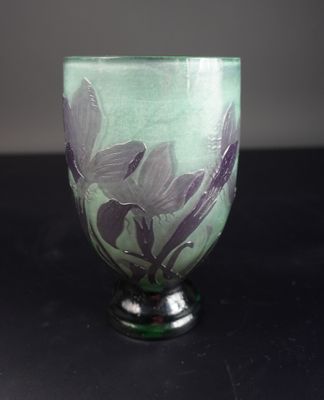 un verre vert orné de fleurs violettes