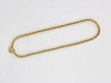 a close up of a gold chain on a white surface