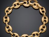 un bracelet en or aux maillons ovales sur fond noir