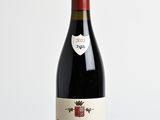 la bouteille de vin rouge est posée sur une table en bois